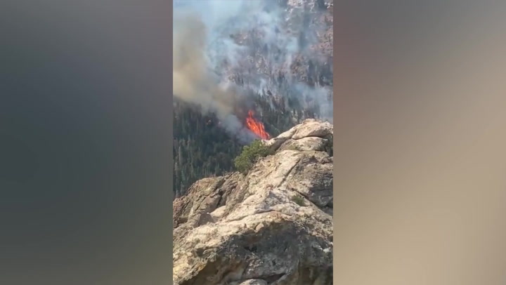 Helicopter drops water onto raging flames of Utah’s Halfway Hill fire