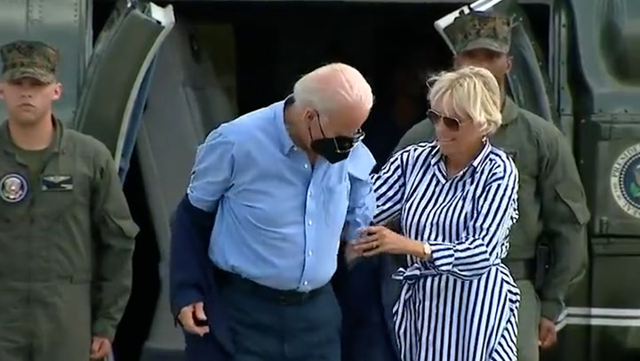 Biden struggles to put on his jacket before dropping his aviators