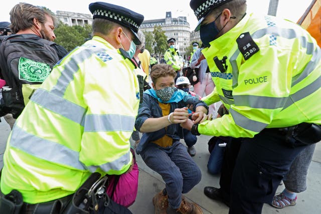 A protester is removed by police officers during an Extinction Rebellion protest in Trafalgar Square, London