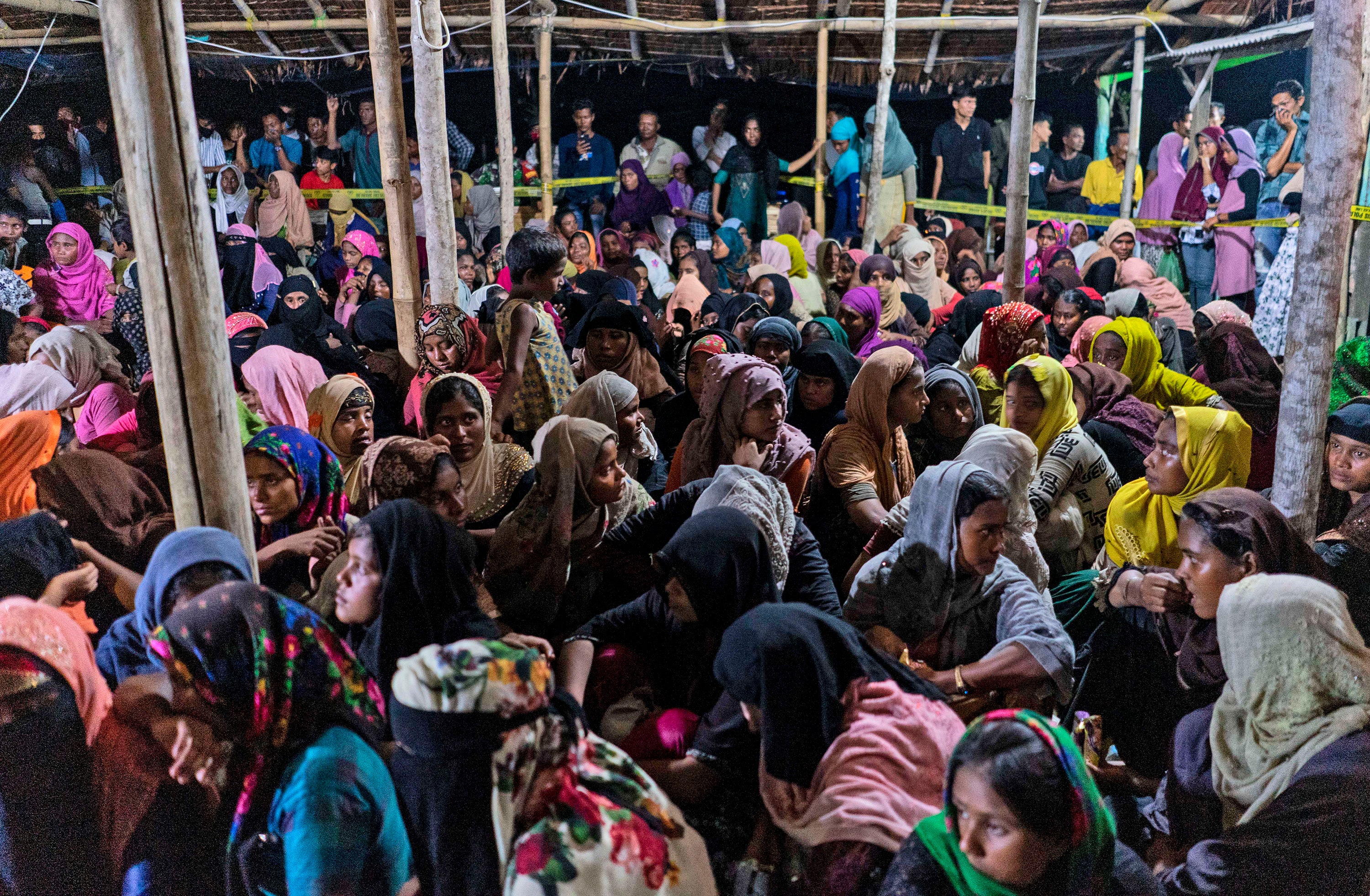 Ethnic Rohingya people rest after the boat carrying them landed in Lhokseumawe, Aceh province, Indonesia