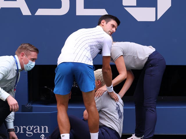 Novak Djokovic checks on the lineswoman he struck with a ball