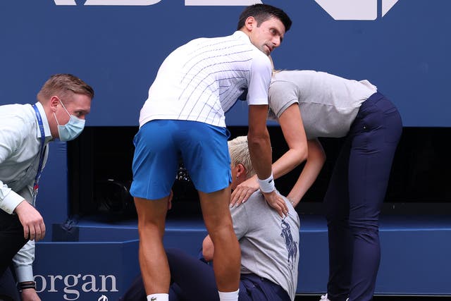 Novak Djokovic checks on the lineswoman he struck with a ball