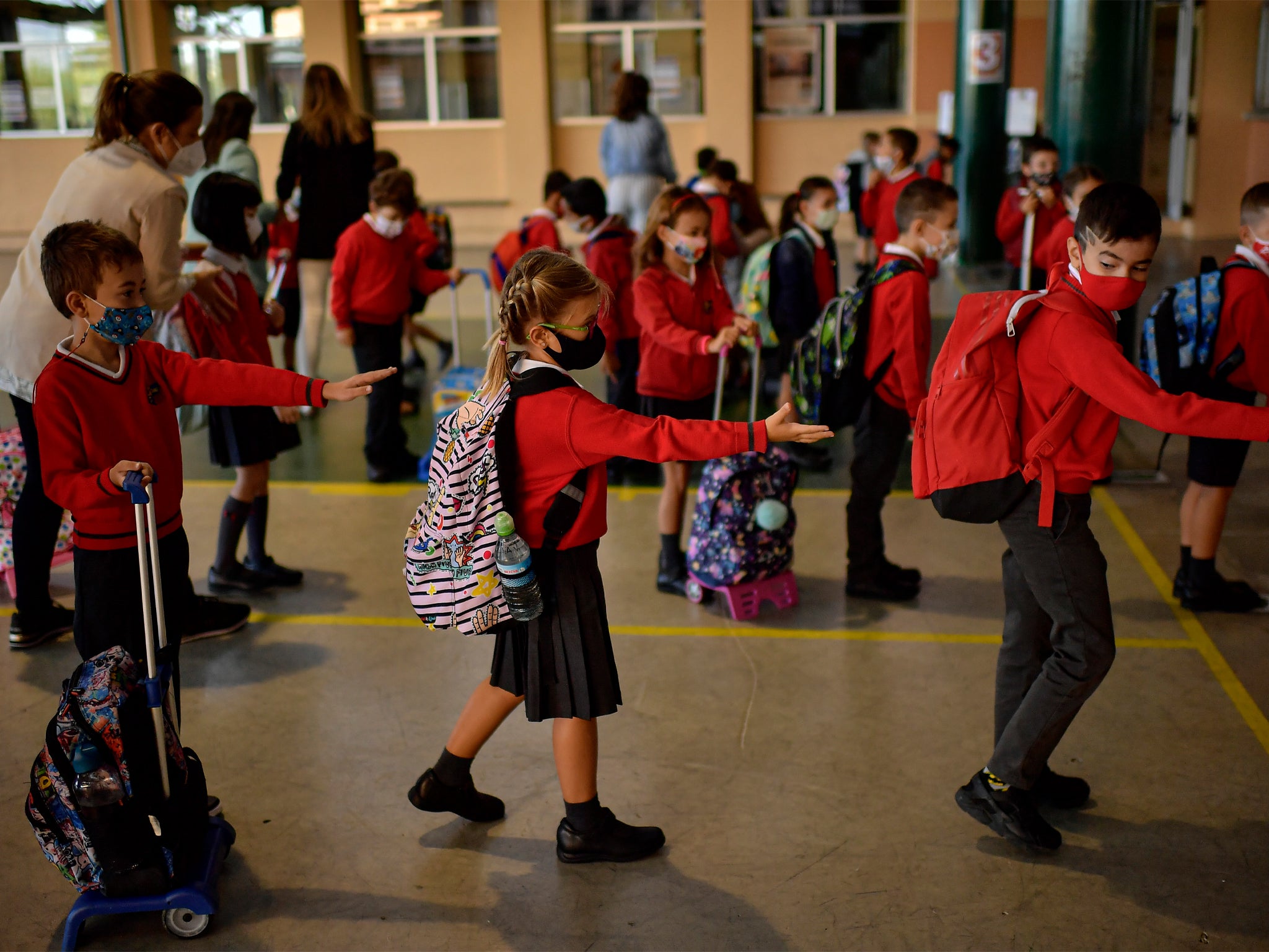 A group of young students social distance before entering a classroom, at the Luis Amigo school, in Pamplona, northern Spain