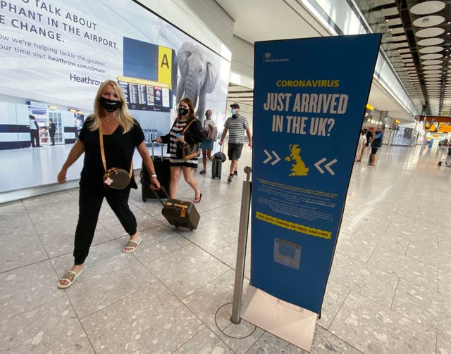Passengers arrive at Heathrow Airport from the Greek island of Mykonos, hours before the 4am quarantine comes into force.