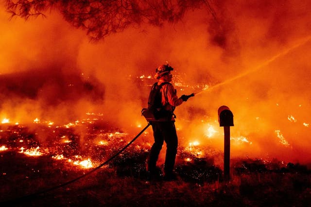 A Butte county firefighter douses flames at the Bear fire in Oroville, California on September 9, 2020