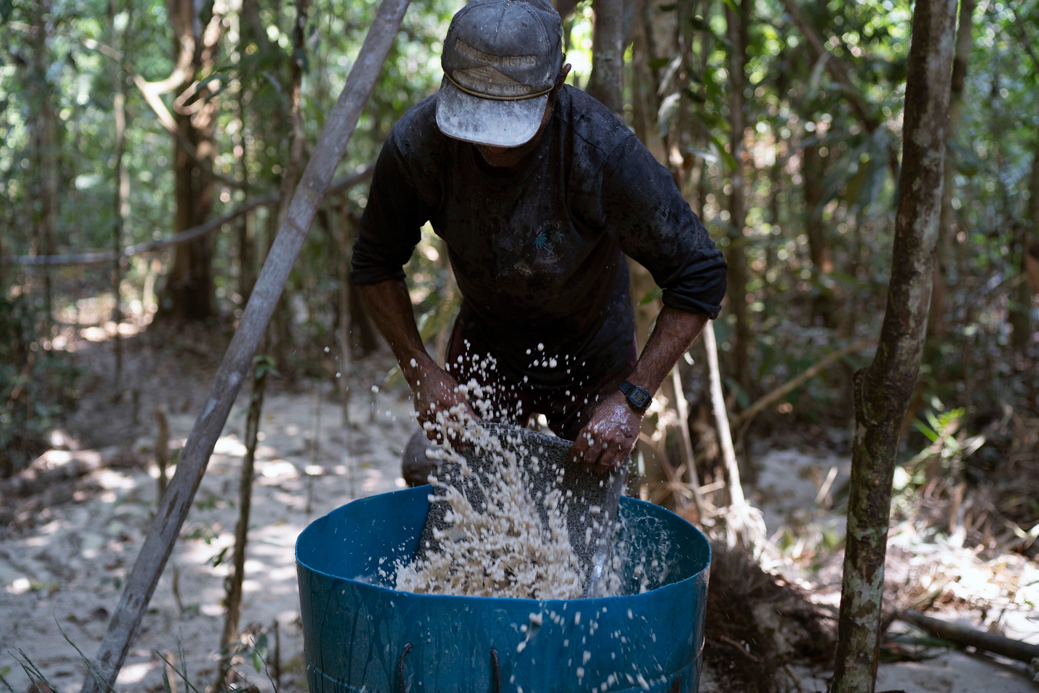 A miner washes a carpet used to trap gold fragments