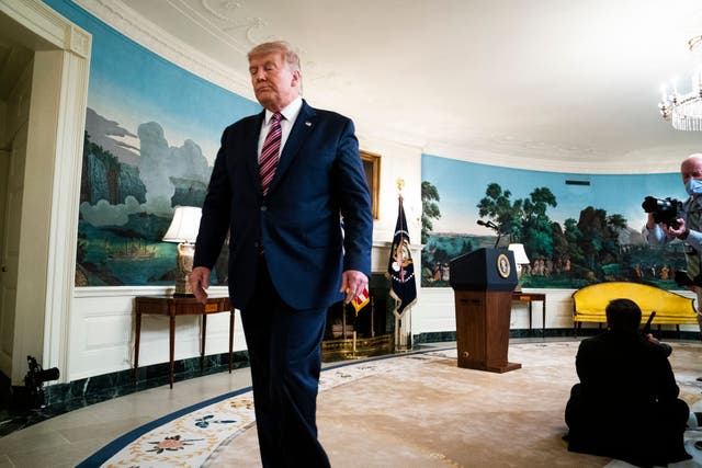 Donald Trump walks away from reporters after answering questions about revelations from Bob Woodward’s new book about his presidency