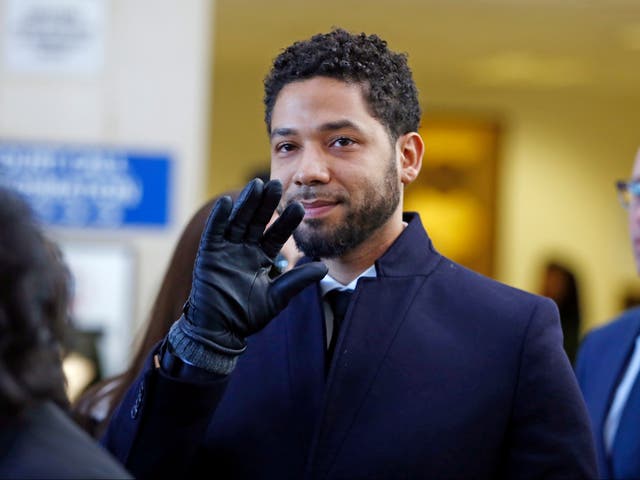 Actor Jussie Smollett waves as he follows his attorney to the microphones after his court appearance at Leighton Courthouse on March 26, 2019 