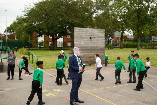 The vice principal wears a PPE face shield in the playground at Greenacres Primary Academy in Oldham