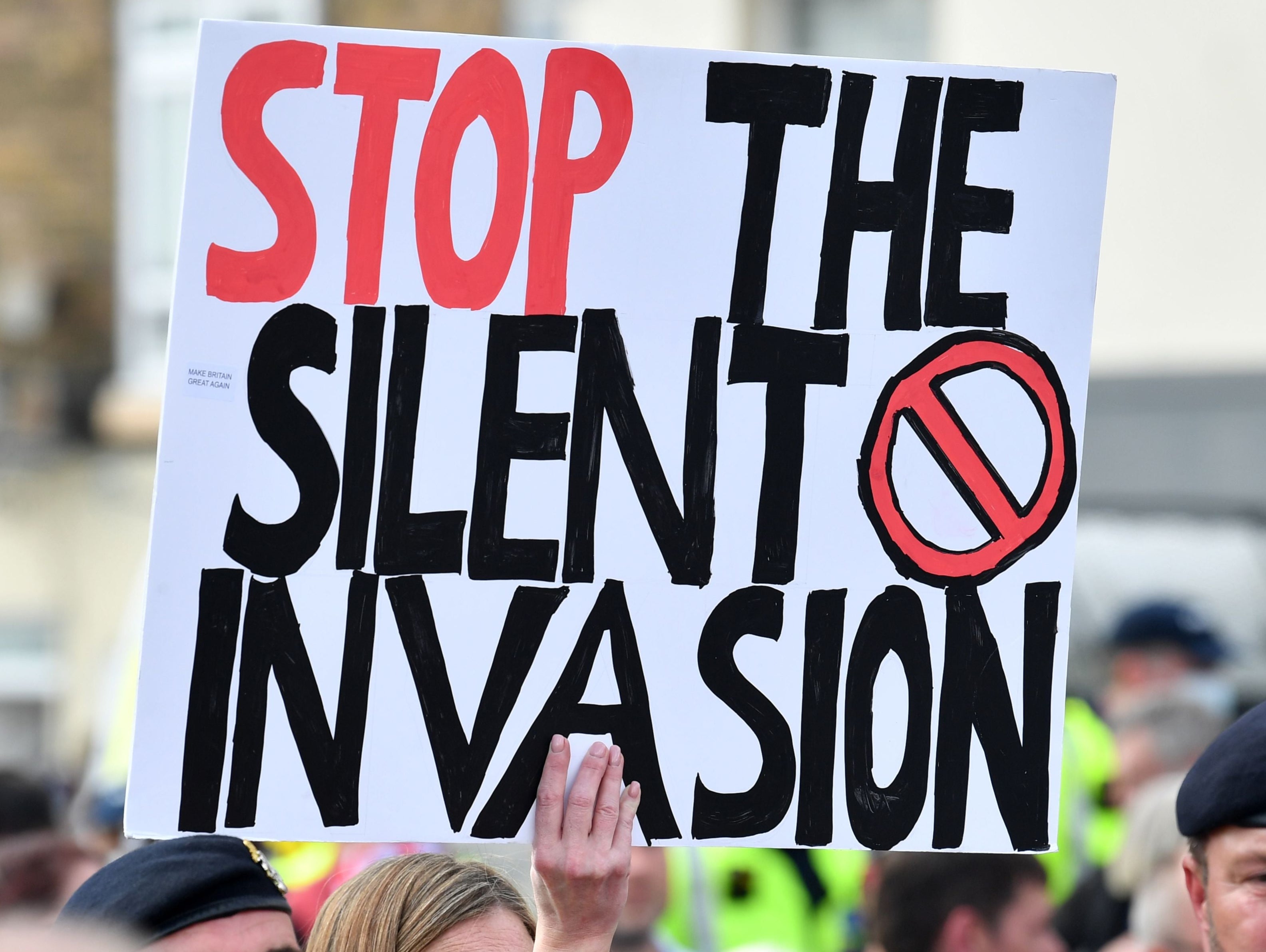 An anti-immigation protester holds up a placard during a demo in Dover on the south-east coast of England, on September 5, 2020
