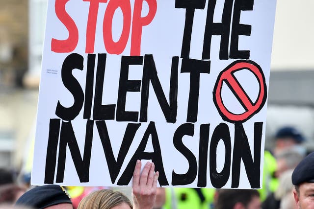  An anti-immigation protester holds up a placard during a demo in Dover on the south-east coast of England, on September 5, 2020
