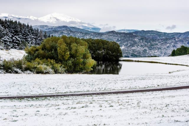 Snow covers the ground near a pond on Red Mountain in Aspen, Colorado, on Wednesday, Sept. 9, 2020. The state has seen wild variations in temperature in the past week