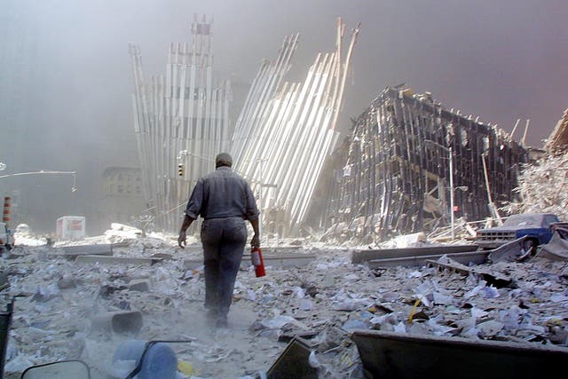 A man with a fire extinguisher walks through rubble after the collapse of the first World Trade Centre Tower 11 September, 2001