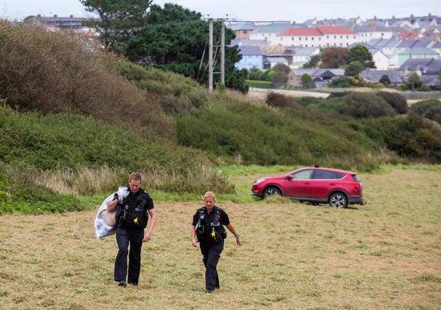 Police attend a field off Trevenson Road in Newquay where an officer suffered burns to his arms and leg