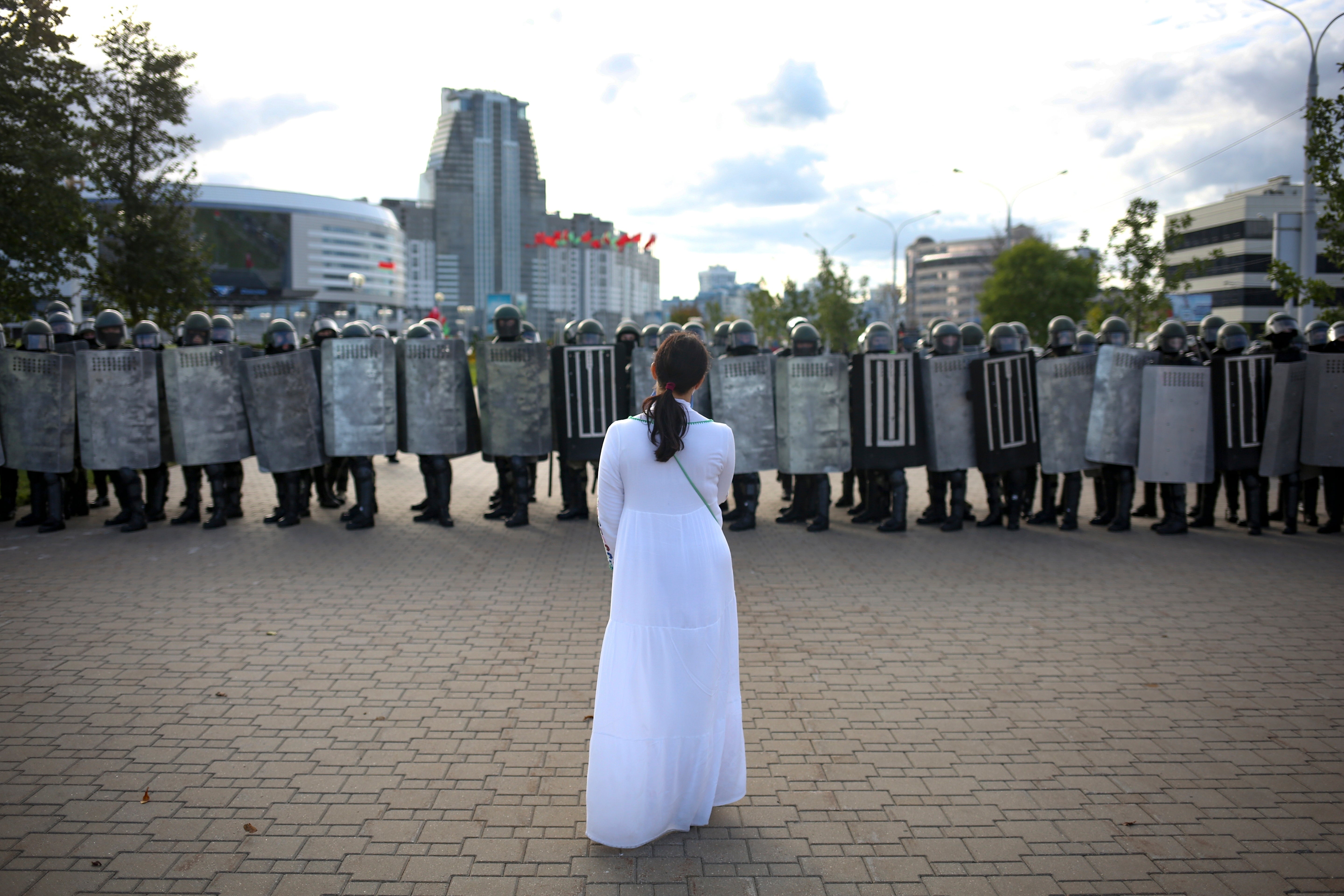 A woman wearing white, stands in front of a riot police line during a Belarusian opposition supporters' rally protesting the official presidential election results in Minsk, Belarus, 13 September 2020