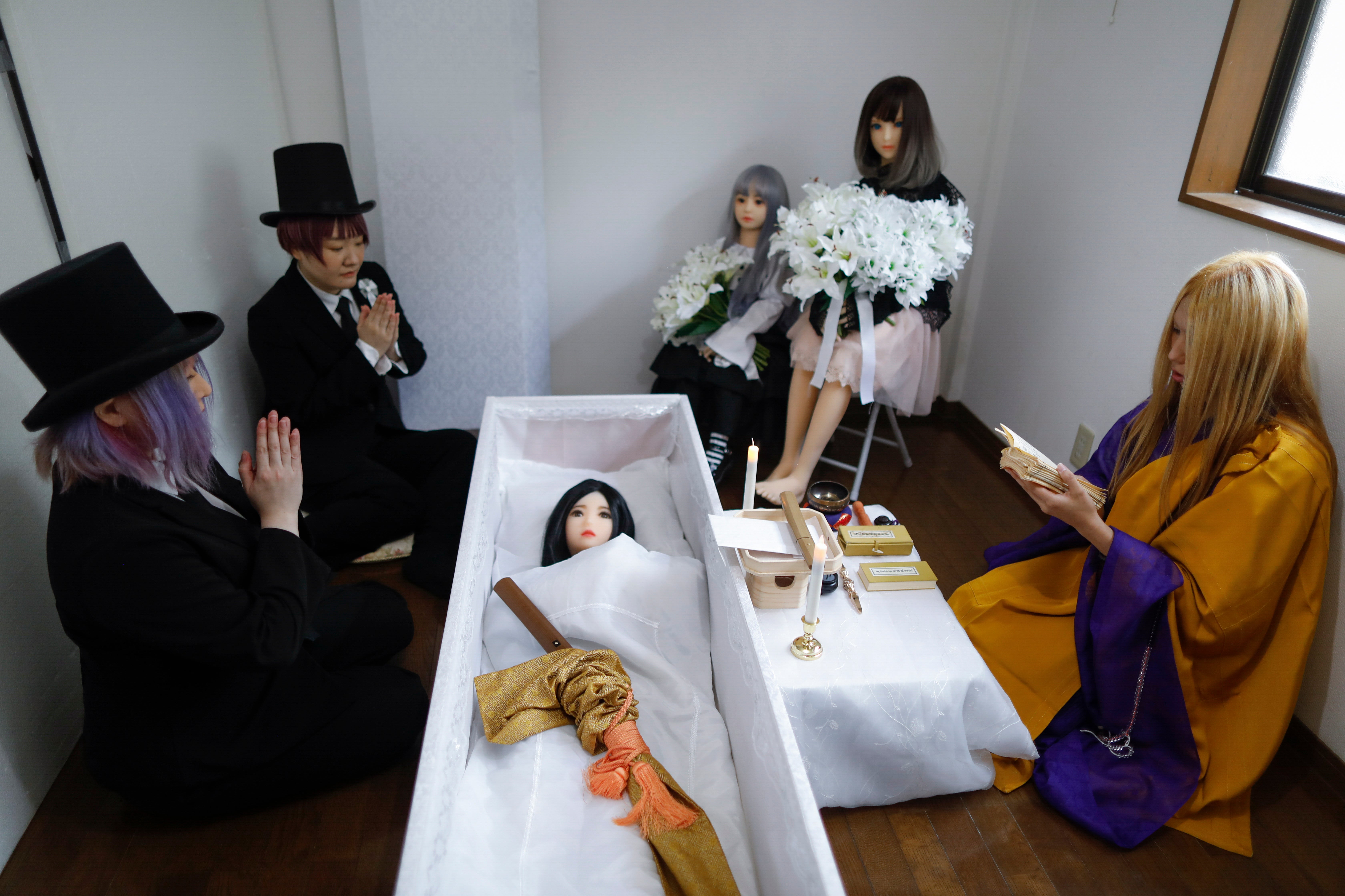 Mourners attend a funeral service for a sex doll named Ran