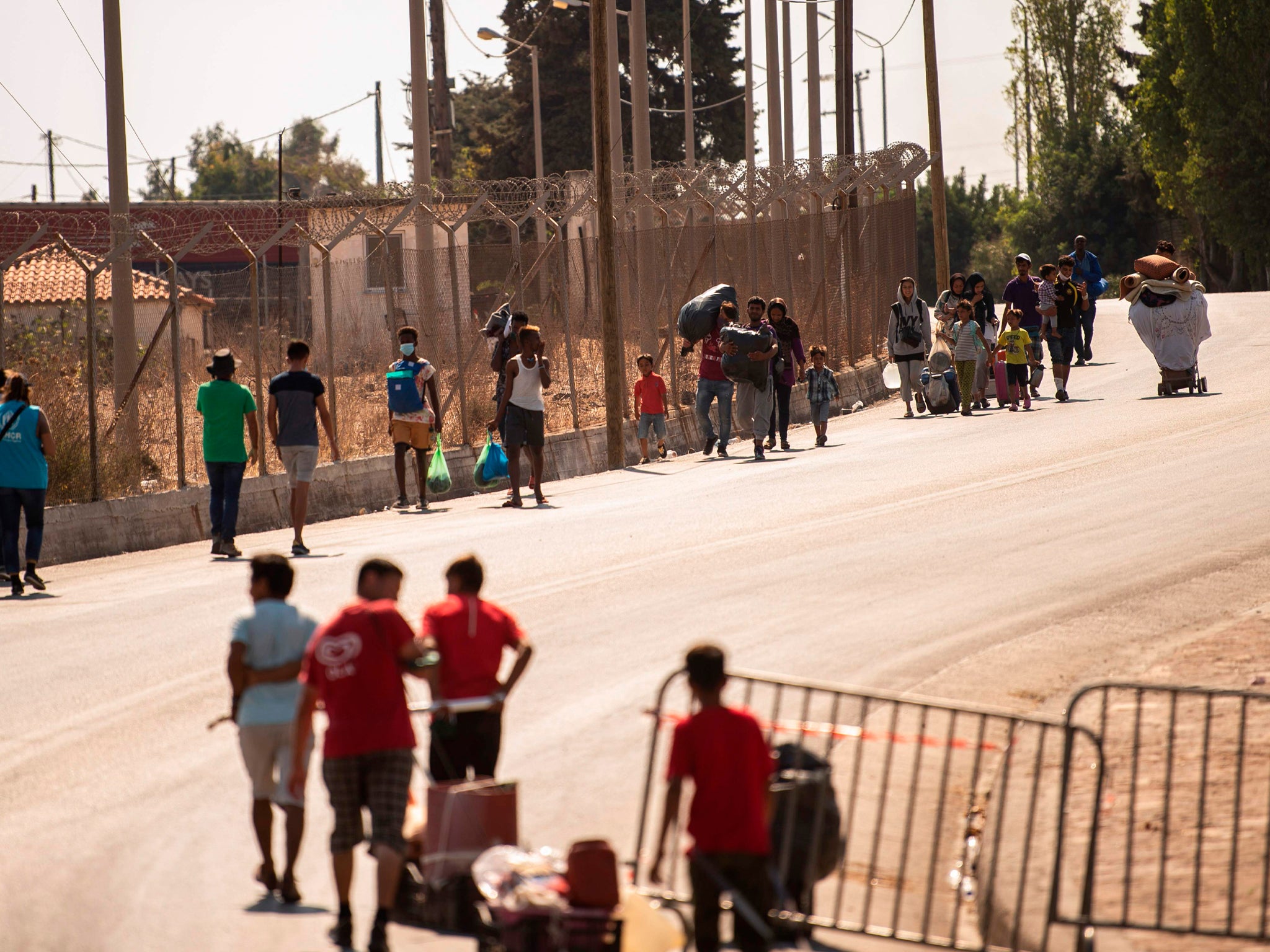 Migrants enter a new temporary camp near Panagiouda, hosting refugees and migrants from the Moria camp destroyed by a fire on the night of September 8th