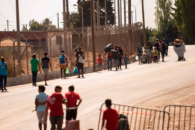 Migrants enter a new temporary camp near Panagiouda, hosting refugees and migrants from the Moria camp destroyed by a fire on the night of September 8th 