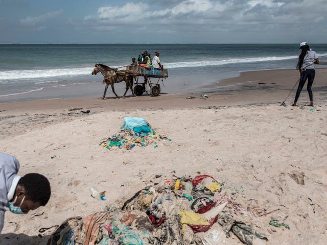 Senegalese youth clean the beach of plastic after organising a beach cleaning day along the coastline in Bargny on August 15, 2020