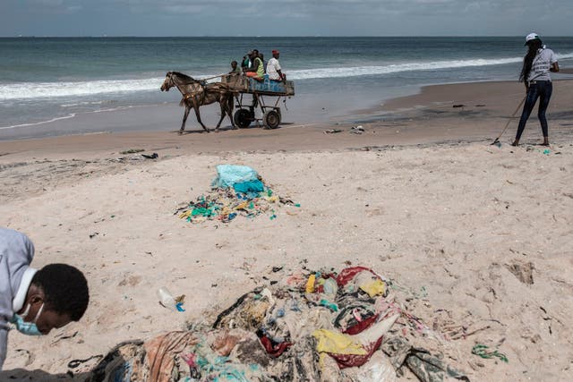 Senegalese youth clean the beach of plastic after organising a beach cleaning day along the coastline in Bargny on August 15, 2020