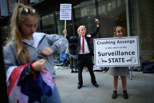 A man wears a Donald Trump mask as supporters of the Wikileaks founder Julian Assange gather outside the Old Bailey