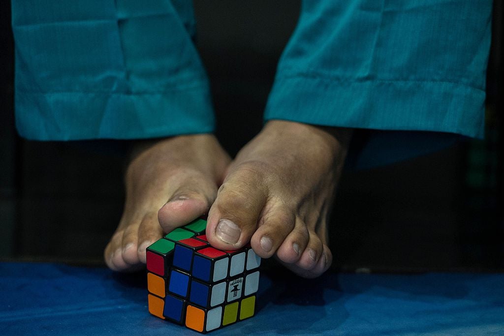 A competitor tries to solve the puzzle using their feet during the Rubik’s Cube World Championship in Sao Paulo, Brazil in 2015
