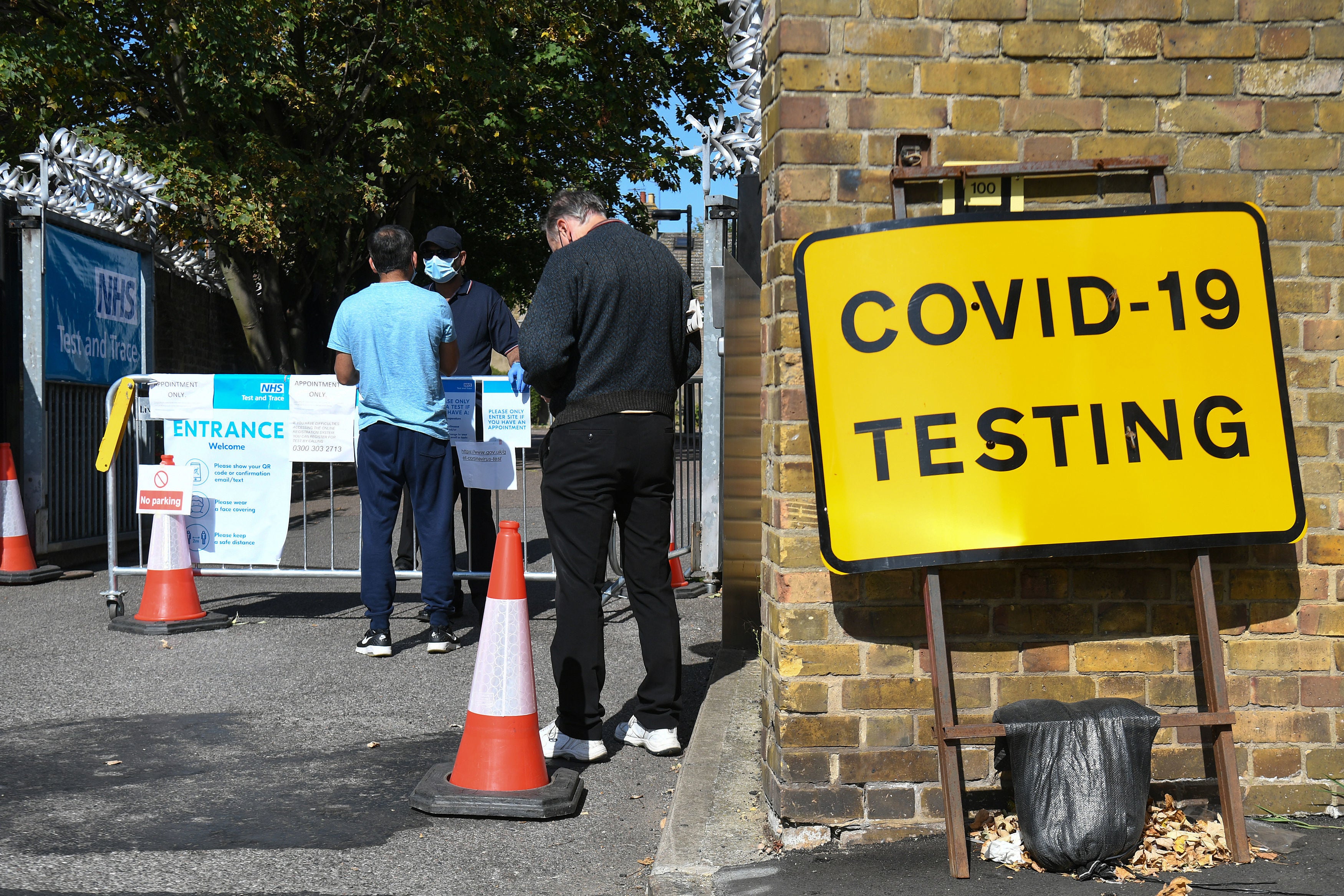 People queue up outside a coronavirus testing centre offering walk-in appointments in east London