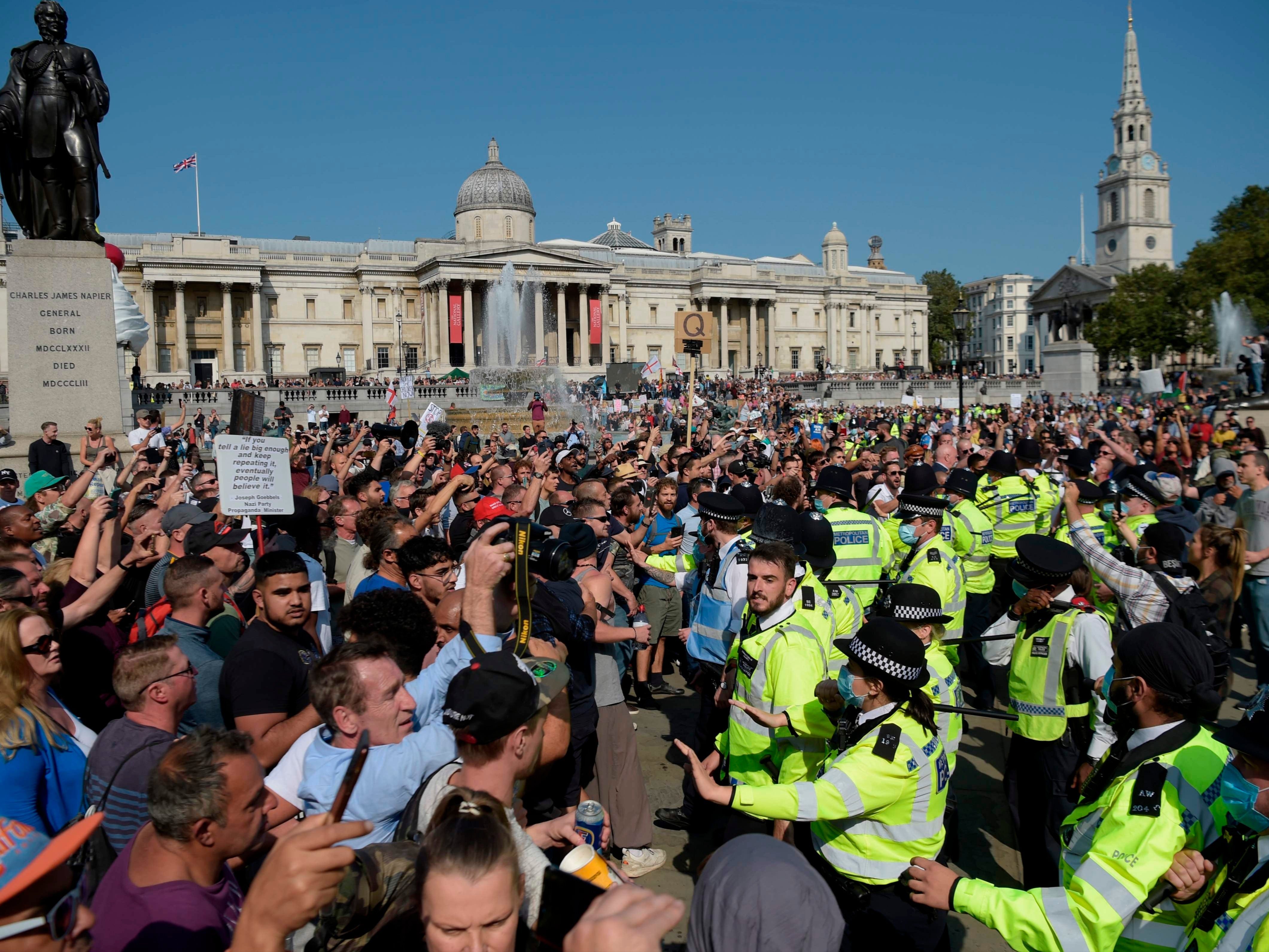 Conspiracy theorists, including Q believers, clash with police at an anti-lockdown protest in Trafalgar Square, London, on Saturday 19 September 2020