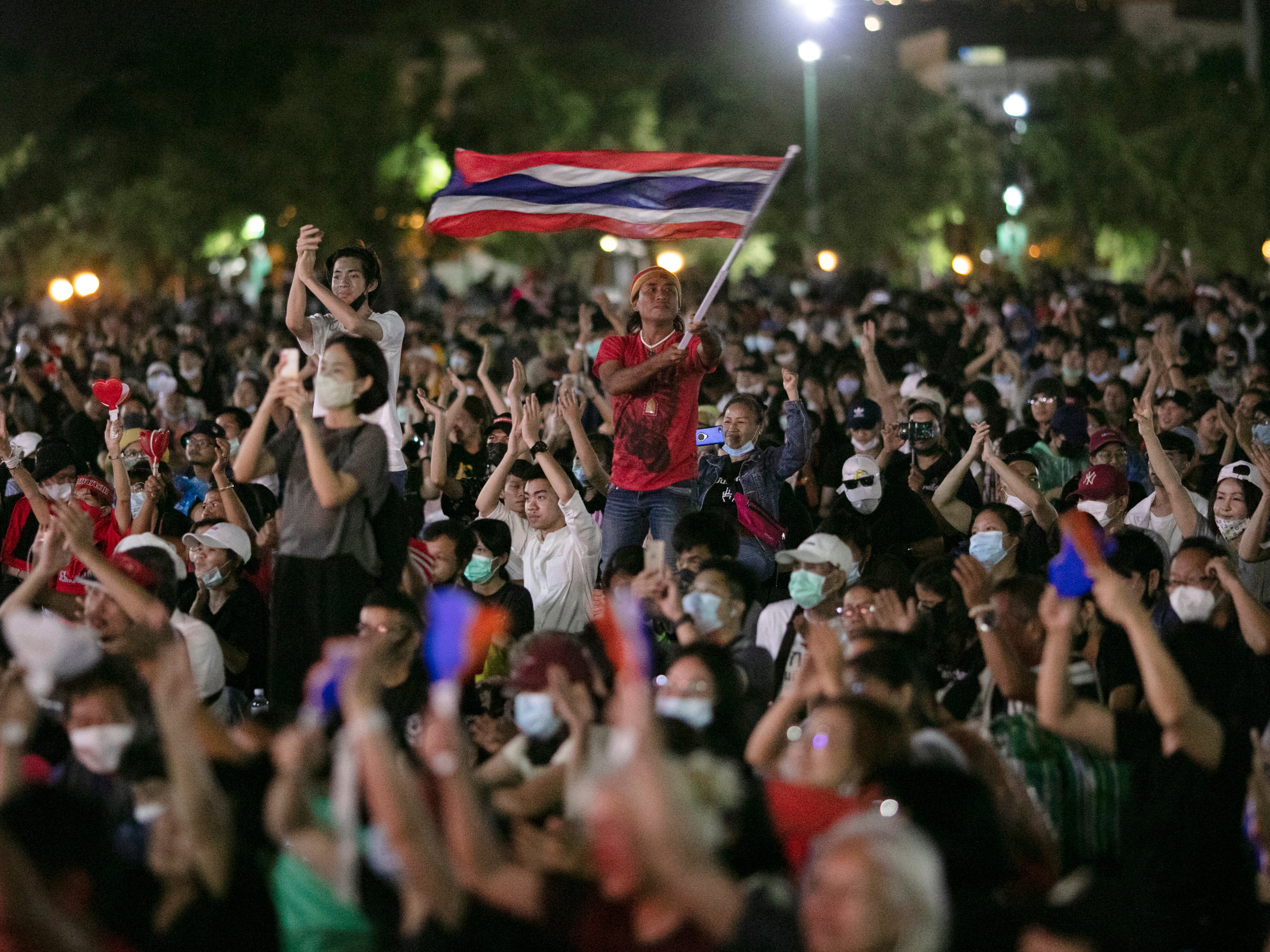 Pro-democracy protesters wave the national flag at the Sanam Luang field during a protest in Bangkok, Thailand