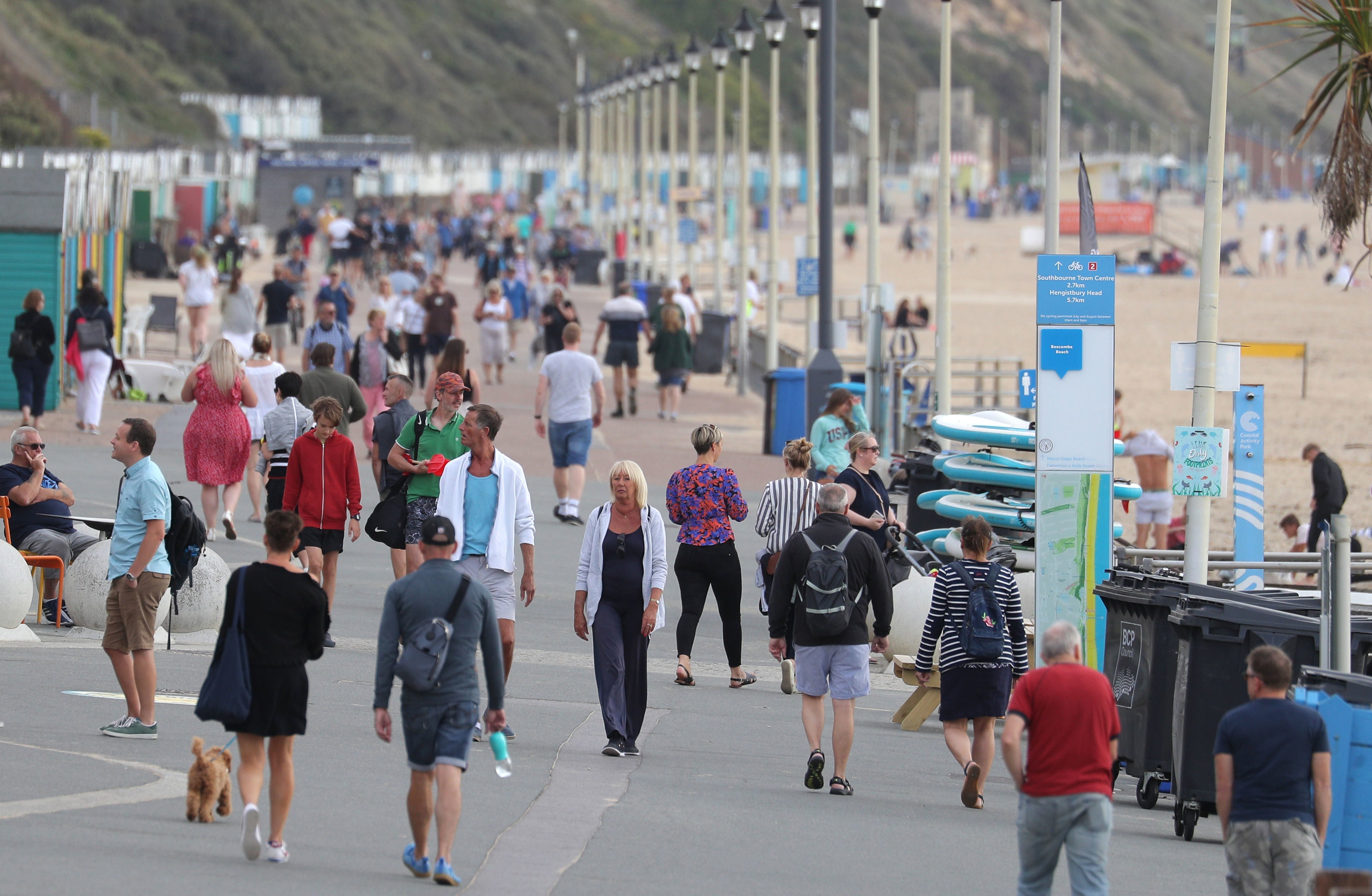 People walk along the beach front at Boscombe Beach in Dorset