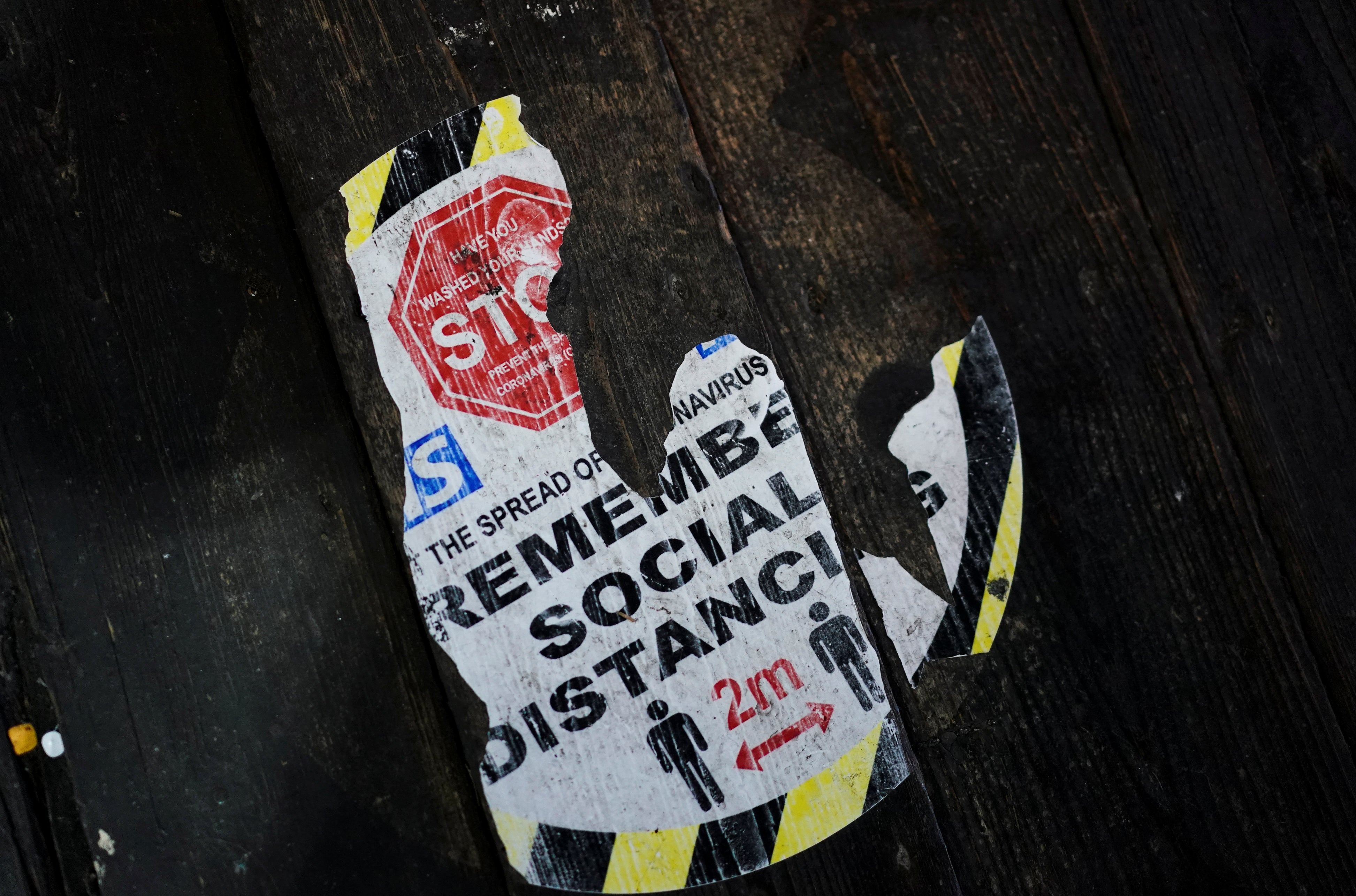 A partially worn social distancing sign can be seen inside Stables Market in Camden, London