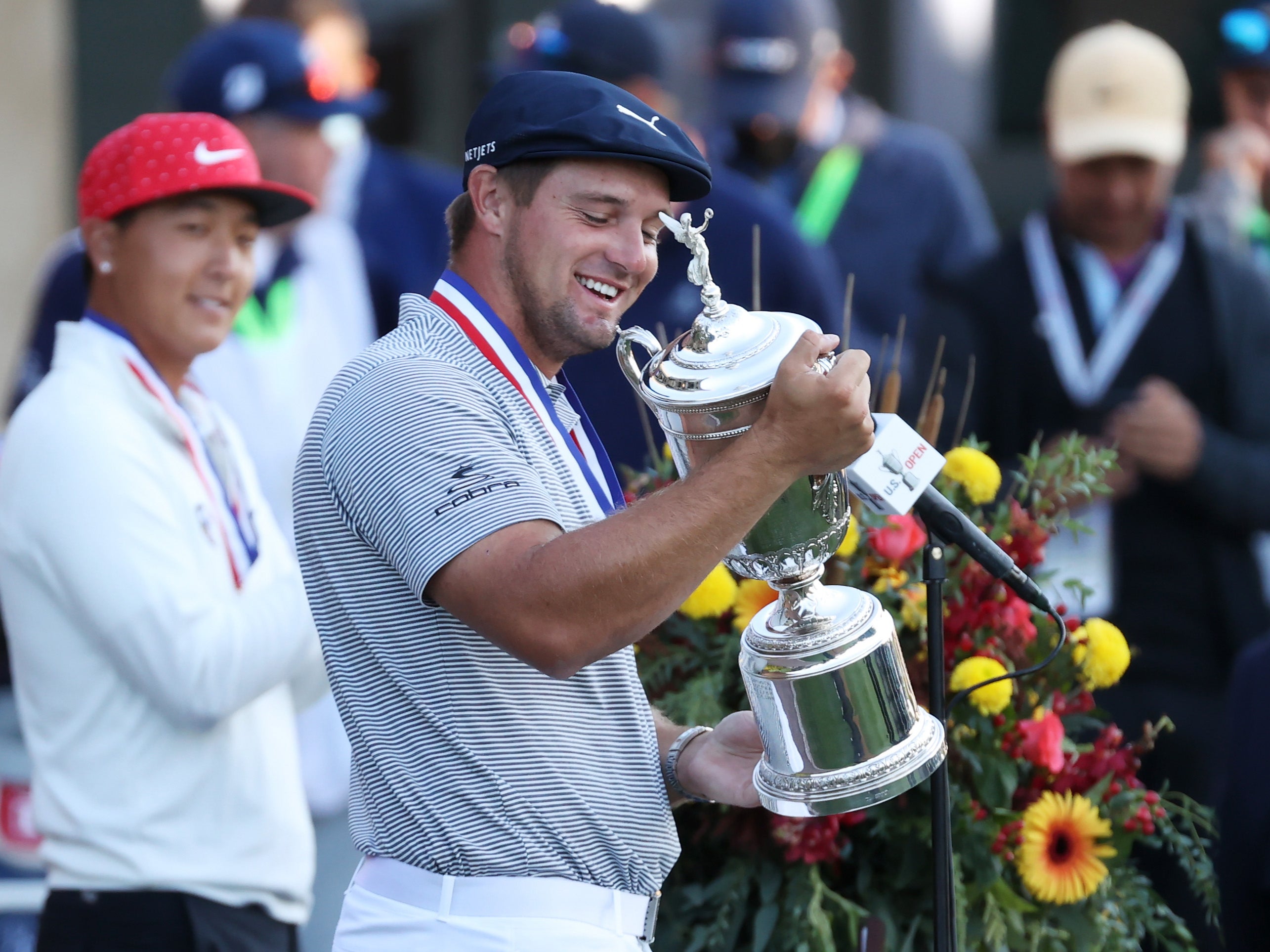 Bryson DeChambeau poses with the trophy