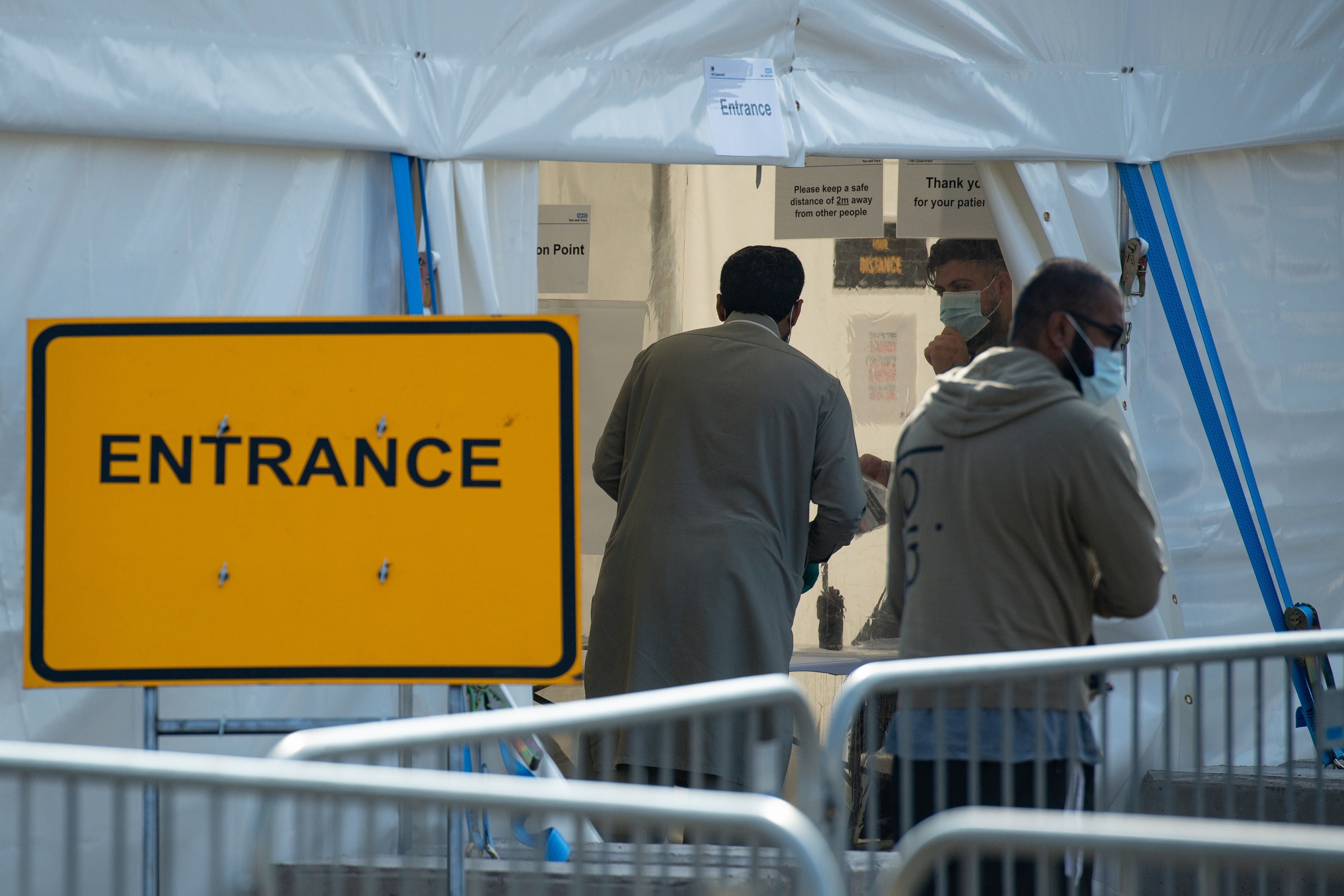 People queue at a Coronavirus testing facility in Sparkbrook, Birmingham