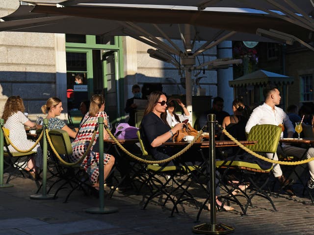 People sit outside at a restaurant in Covent Garden, London, 21 September 2020. 