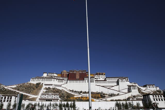A Chinese flag flutters on a pole in front of the Potala Palace in Lhasa, Tibet Autonomous Region