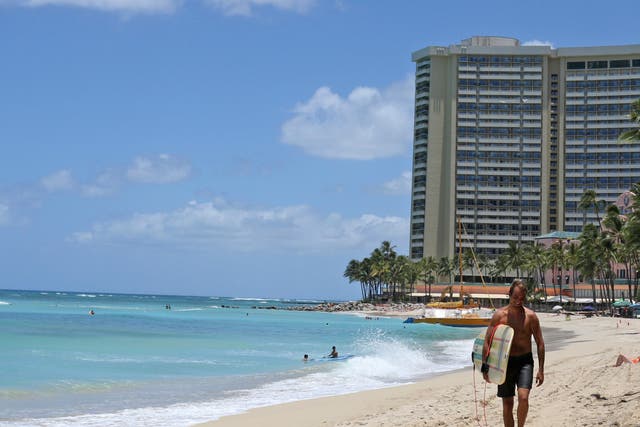<p>FILE-A surfer walks on a sparsely populated Waikiki Beach in Honolulu.</p>