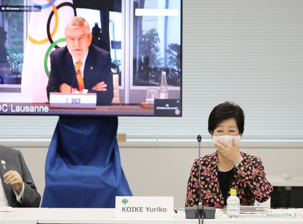 La gobernadora de Tokio, Yuriko Koike, reacciona junto a una pantalla que muestra al presidente del Comité Olímpico Internacional (COI), Thomas Bach, durante una reunión en video de la Comisión de Coordinación del COI para los Juegos Olímpicos de Tokio.