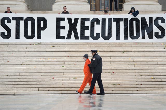 <p>Randy Gardner is removed by police while wearing his executed brother's prison jumpsuit during a protest against the death penalty at the US Supreme Court</p>