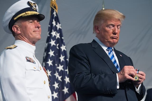 President Donald Trump looks on next to Admiral Paul Zukunft (L) as he retires as Commandant of the US Coast Guard during a Change of Command ceremony  in 2018