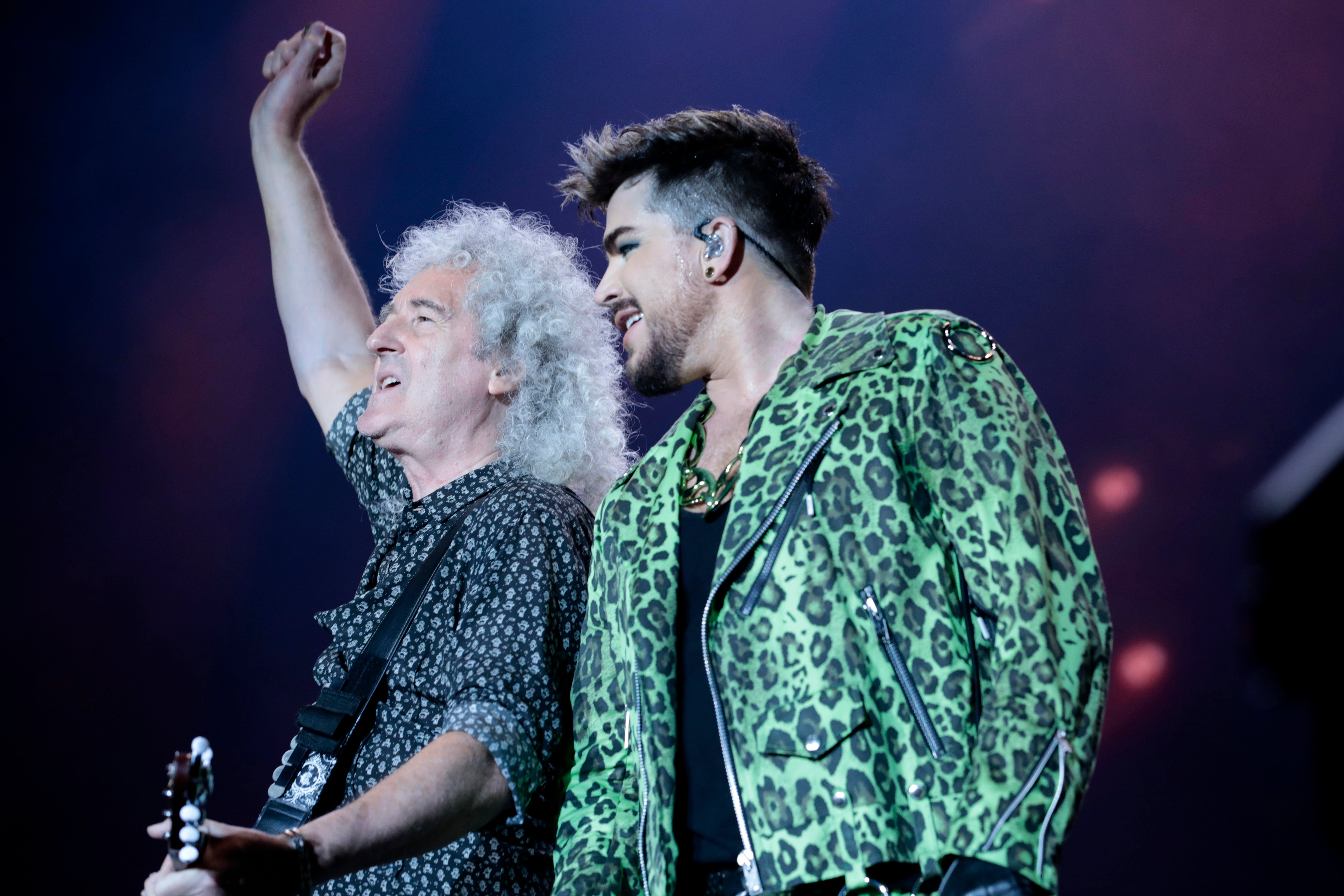 May (left) still performs with Queen + Adam Lambert