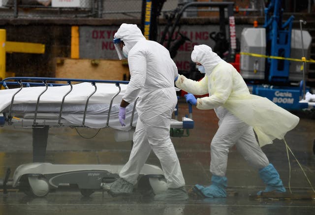 <p>File: Medical personnel move a deceased patient to a refrigerated truck in New York </p>