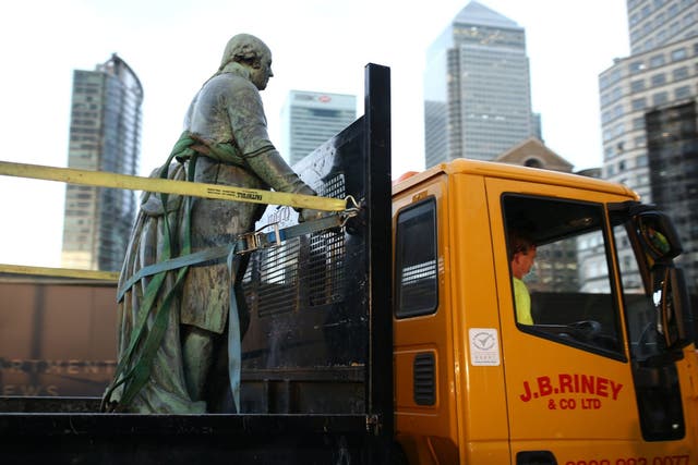 Workers take down a statue of slave owner Robert Milligan at West India Quay, in east London's Docklands