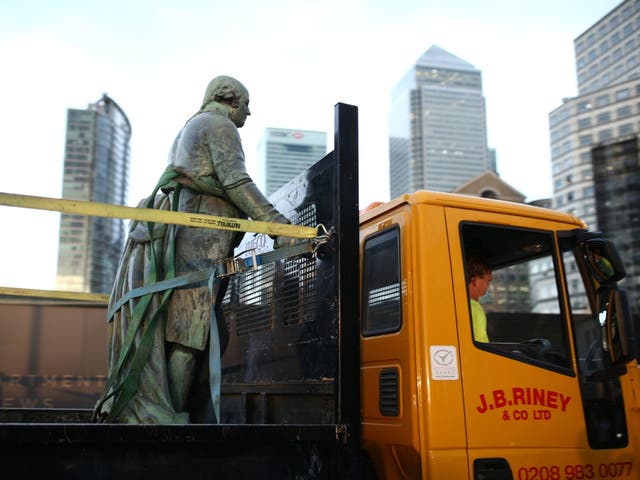 Workers take down a statue of slave owner Robert Milligan at West India Quay, in east London's Docklands