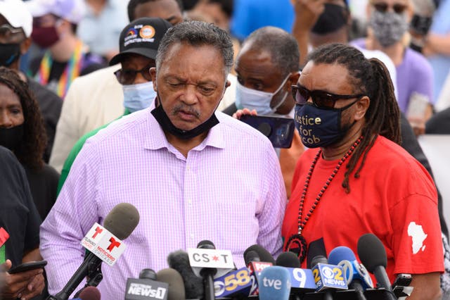 Jesse Jackson (izq.) y Justin Blake hablan con los medios de comunicación en una celebración comunitaria y piden justicia para Jacob Blake mientras el grupo de base MoveOn enarbola una pancarta en un avión e impulsa una valla publicitaria móvil llamando a los votantes a "Rechazar la violencia de Trump"