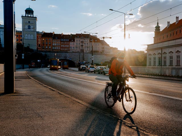 *description*Man rides bike on Aleja Solidarnosci in oWarsaw 