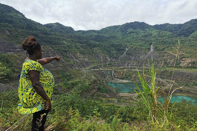 Local resident and advocacy group member Theonila Roka Matbob standing in front of the abandoned Panguna mine pit in Bougainville