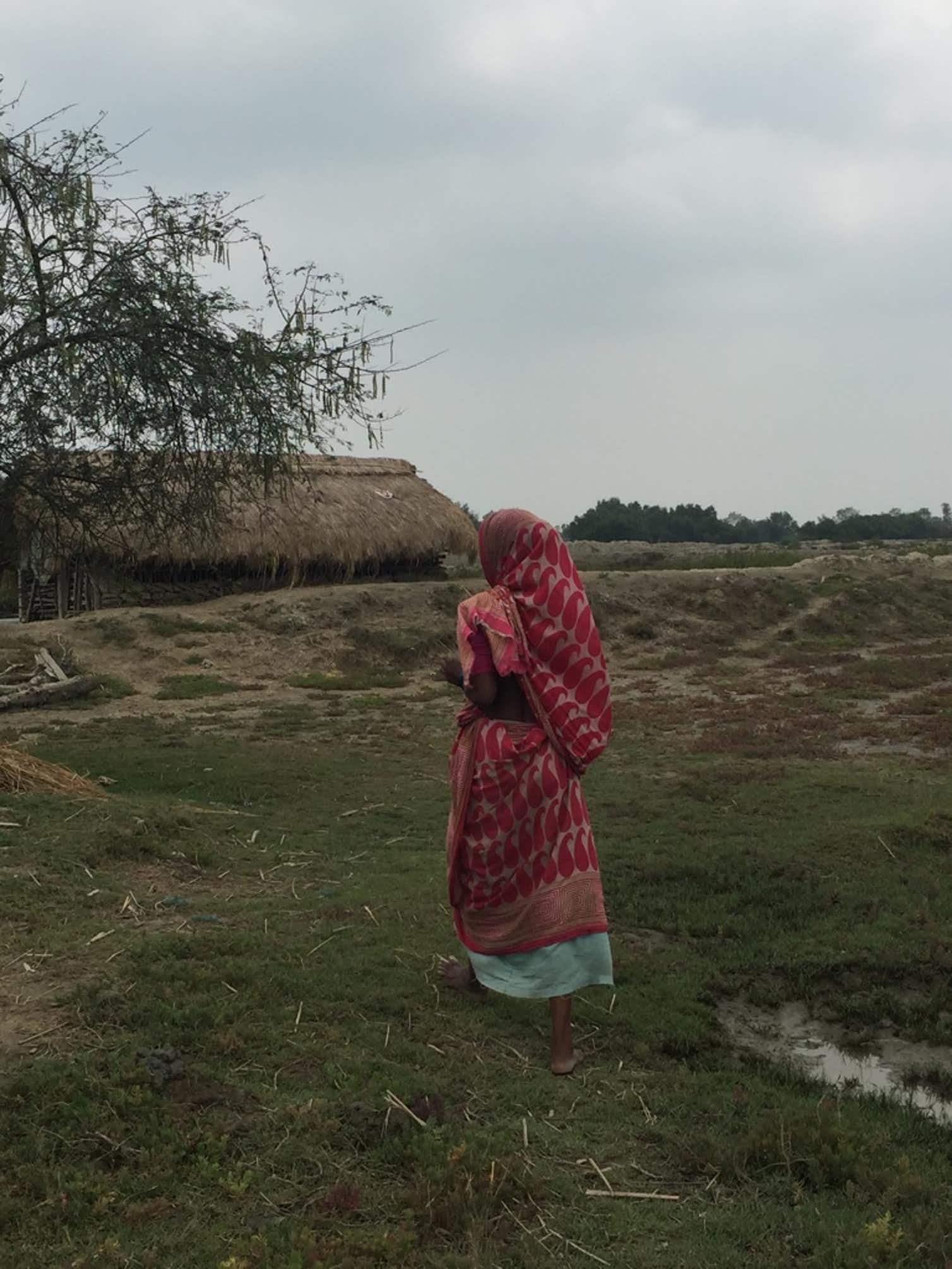 A research participant walking towards her house in West Bengal