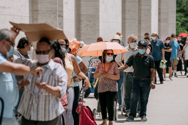 New Yorkers in need wait in a long line to receive free produce, dry goods, and meat at a Food Bank For New York City distribution event at Lincoln Center on July 29, 2020