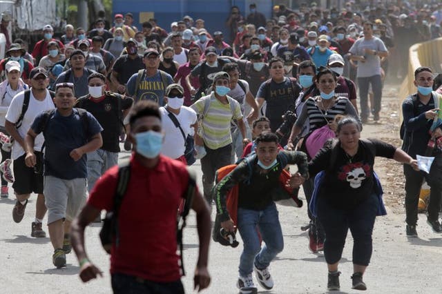 Unos migrantes tratan de cruzar la frontera desde Corinto, Honduras, hacia Corinto, Guatemala, el jueves 1 de octubre de 2020. 