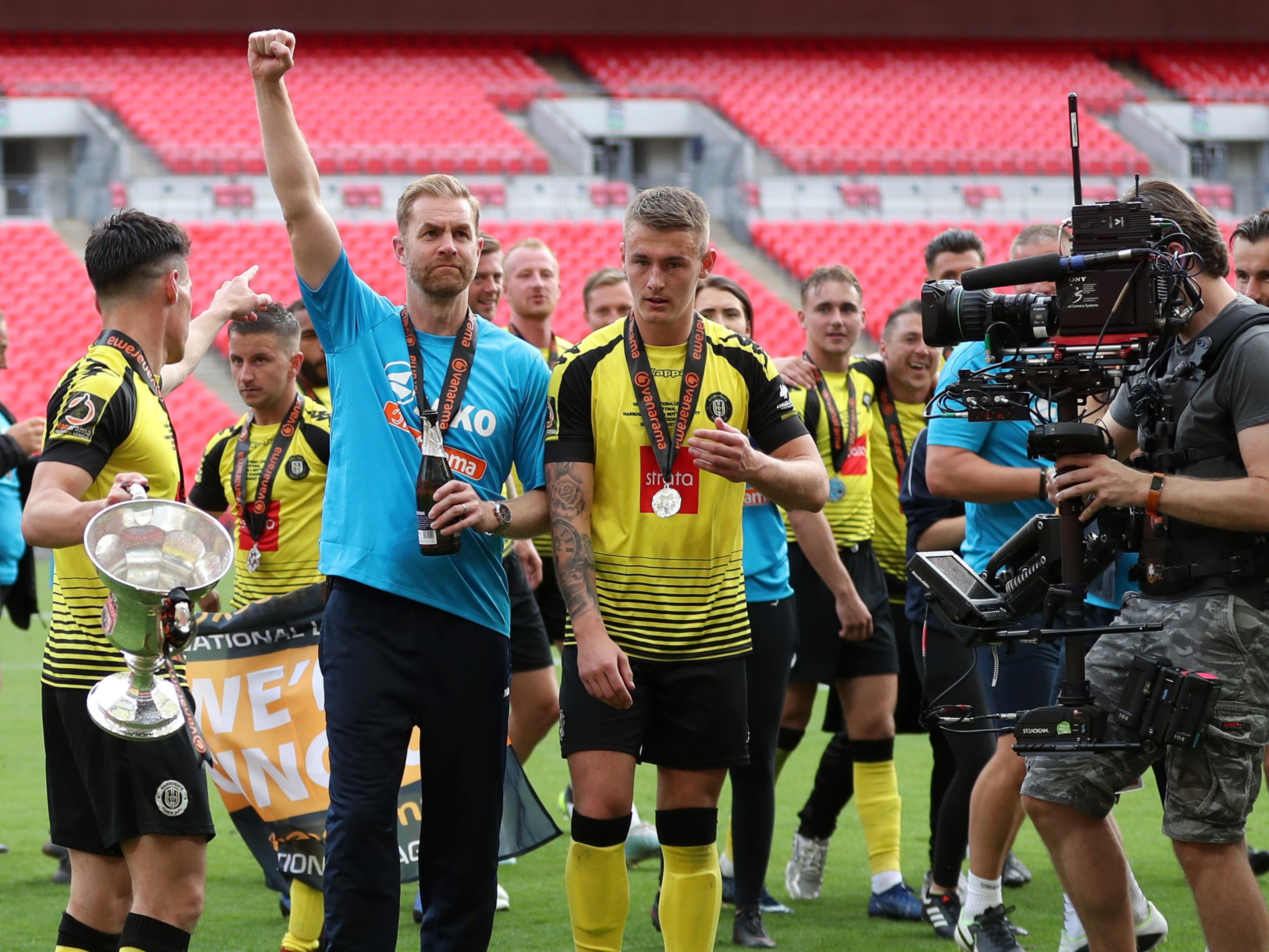 Harrogate Town coach Simon Weaver celebrates promotion to the Football League with his players